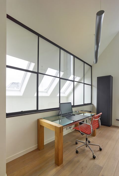 Stalen ramen in werkkamer zorgen voor een optimale lichtinval in Prinsenbeek.
