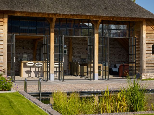 Openslaande stalen deuren in een eikenhouten bijgebouw van Rasenberg in Werkhoven.